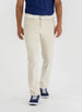 Men's Clemson Pant in Stone, on-model front view featuring a light tan five-pocket style with a button closure and white belt worn with a navy polo and navy golf shoes