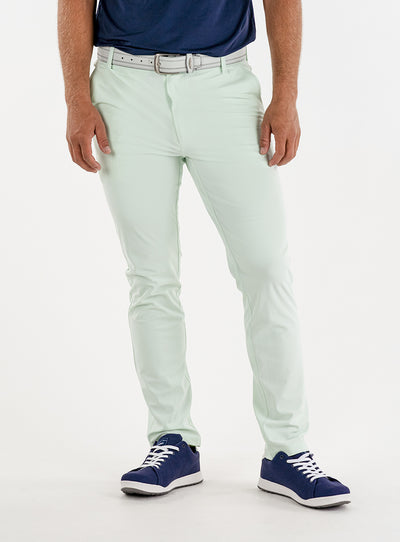 Men's Quest Pant in Light Mint, front on-model view featuring mint green pants with a button waistband closure and side pockets, styled with a navy shirt, white belt, and navy shoes
