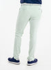 Men's Quest Pant in Light Mint, back on-model view featuring mint green pants with button-closure back pockets, styled with a navy shirt, white belt, and navy shoes