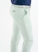 Men's Quest Pant in Light Mint, close-up side and back detail view featuring the button-closure back pocket with a small logo tab, styled with a white belt and navy shirt