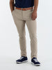Men's Quest Pant in Light Khaki, front on-model view featuring khaki pants with a button waistband closure and side pockets, styled with a navy shirt, brown belt, and navy shoes