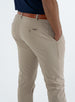 Men's Quest Pant in Light Khaki, close-up back detail view featuring the button-closure back pocket with a small embroidered logo, styled with a brown belt