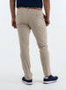 Men's Quest Pant in Light Khaki, back on-model view featuring khaki pants with button-closure back pockets and a small embroidered logo on back pocket, styled with a navy shirt, brown belt, and navy shoes