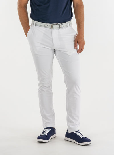 Men's Quest Pant in White, front on-model view featuring white pants with a button waistband closure and side pockets, styled with a navy shirt, gray belt, and navy shoes