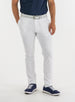 Men's Quest Pant in White, front on-model view featuring white pants with a button waistband closure and side pockets, styled with a navy shirt, gray belt, and navy shoes