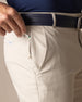 Men's Maverick Twill Pant in Cashew, close detailed view of the front zippered pocket with a golf tee being inserted, highlighting the khaki twill fabric and Straight Down patch, with navy belt