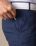 Men's Maverick Twill Pant in New Indigo, close detailed view of the front zippered pocket with a golf tee being inserted, highlighting the navy twill fabric and white belt