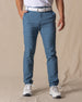 Men's Maverick Twill Pant in Petrol, front view on model featuring solid petrol blue slim fit golf pants with white belt and white golf shoes