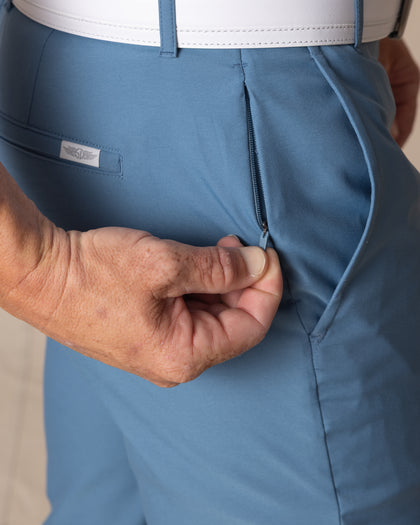 Men's Maverick Twill Pant in Petrol, close detailed view of the front zippered pocket being opened, highlighting the petrol blue twill fabric and Straight Down patch, with white belt