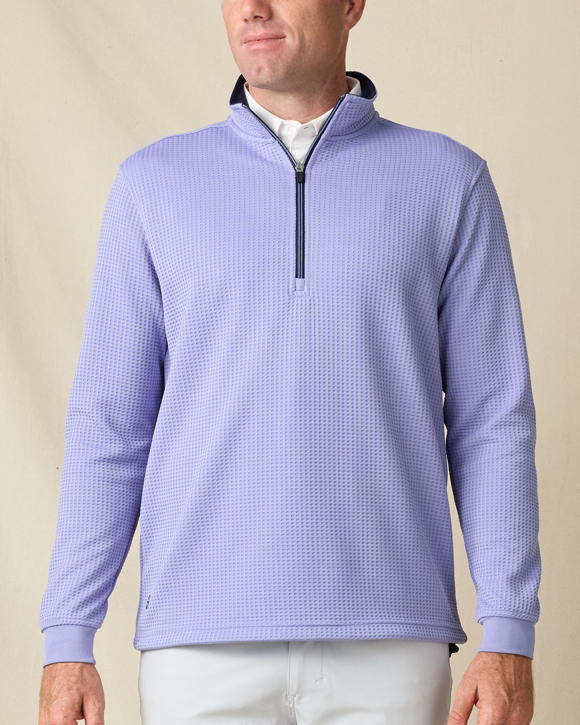 Model wearing the Optic Quarter Zip in Blue Shade, featuring textured waffle-knit fabric and a contrast navy zipper and collar lining.