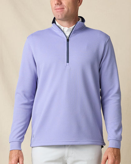 Model wearing the Optic Quarter Zip in Blue Shade, featuring textured waffle-knit fabric and a contrast navy zipper and collar lining.