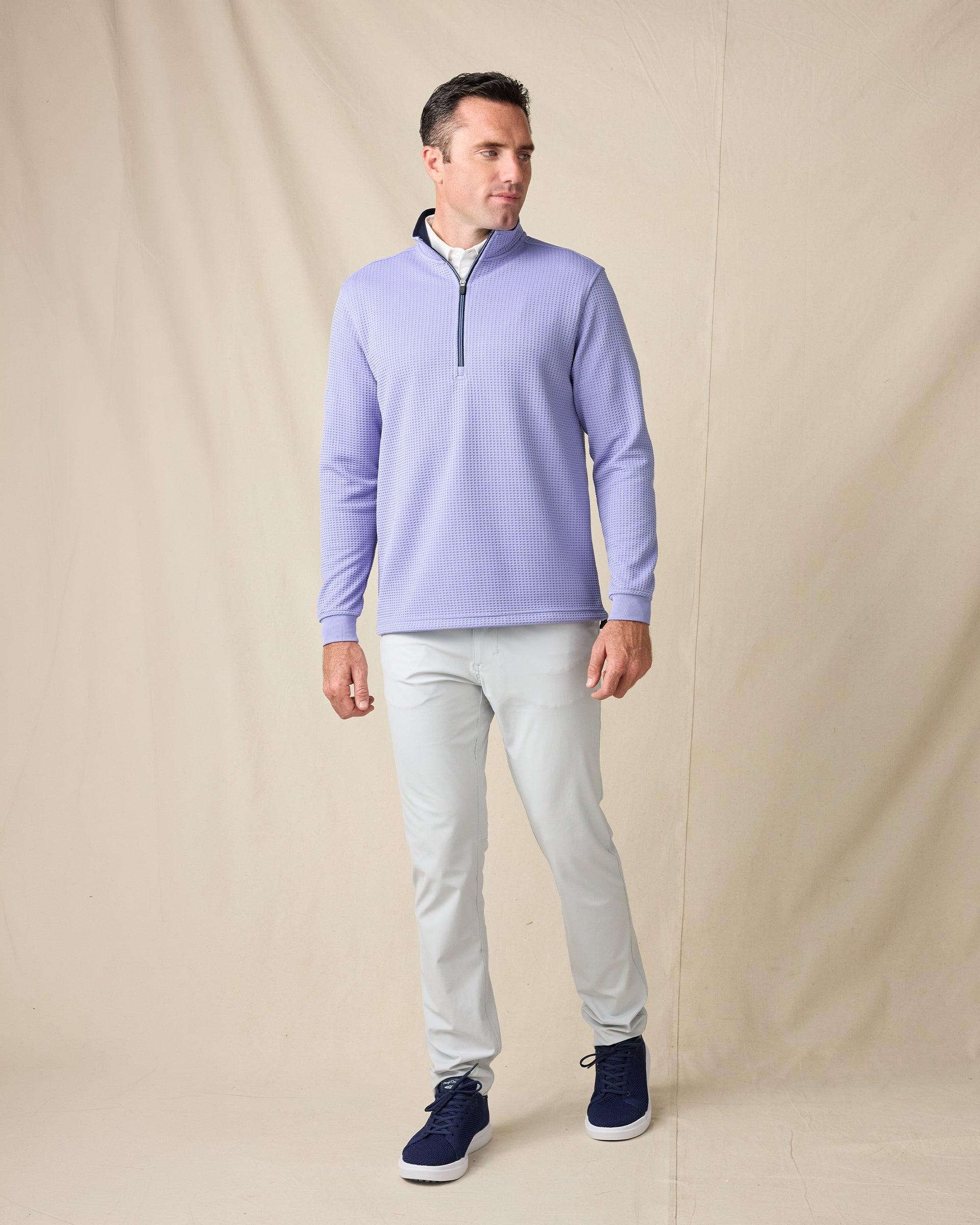 Model wearing the Optic Quarter Zip in Blue Shade with light gray pants and navy sneakers.
