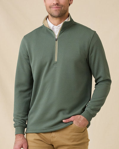 Model wearing the Optic Quarter Zip in Dark Forest over a white polo with tan pants, showing the textured waffle knit and contrast collar.