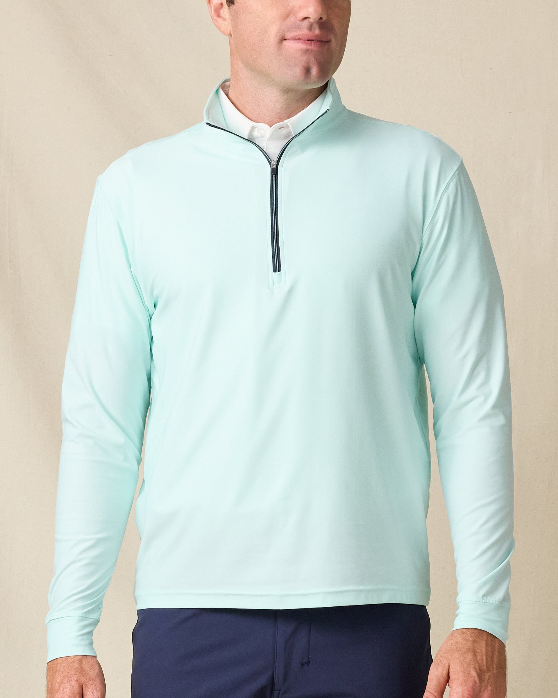 Model wearing the Crusher Quarter Zip in Mint Tea, featuring a clean solid finish with a contrast navy zipper.
