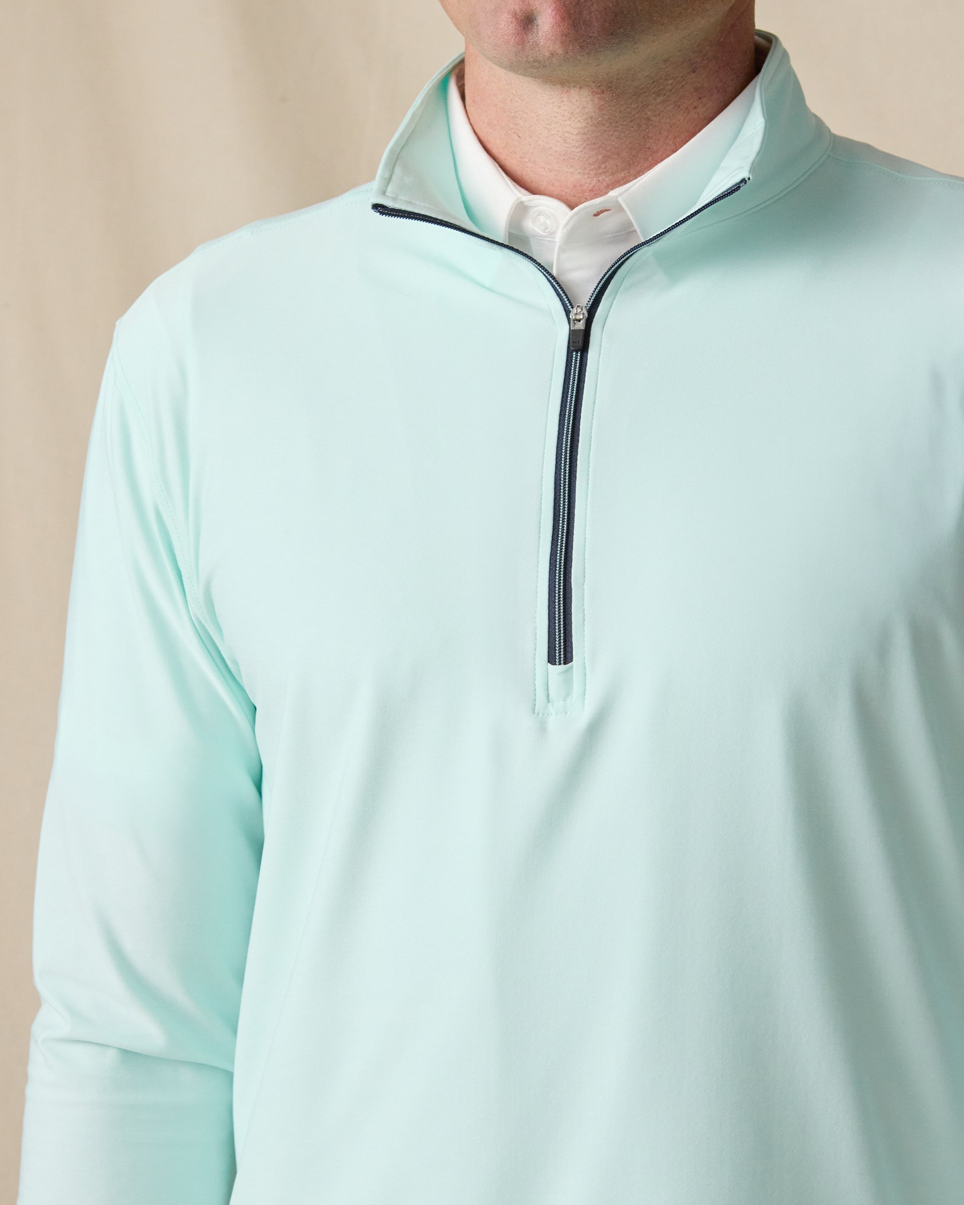 Close-up of the men’s Crusher Quarter Zip in Mint Tea, featuring a contrast quarter-zip closure and stand collar layered over a white polo.