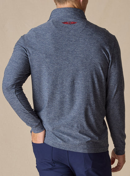 Men's Crusher Quarter Zip in New Indigo, back model view featuring a navy heathered body with red contrast logo embroidery at the upper back, layered over a white collared shirt with navy pants