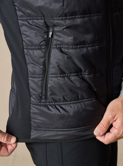 Men's Delta Vest in Black, close-up side detail featuring zip hand pocket, horizontal quilted baffles, and contrast softshell side panel with stretch hem detail