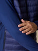 Men's Patton Jacket in Indigo, close-up detail view featuring the smooth stretch knit sleeve, zippered side pocket, and quilted puffer body panel
