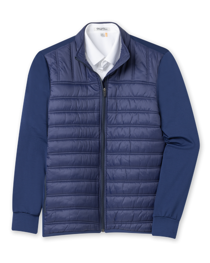 Men's Patton Jacket in Indigo, flat lay front view featuring a solid navy quilted insulated body with knit sleeves, full zip closure, stand collar, and side zip pocket