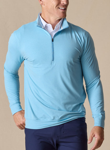 Men's Ballard Quarter Zip in Niagara, on model front view highlighting the light blue body and quarter zip layered over a white polo