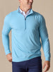 Men's Ballard Quarter Zip in Niagara, on model front view highlighting the light blue body and quarter zip layered over a white polo