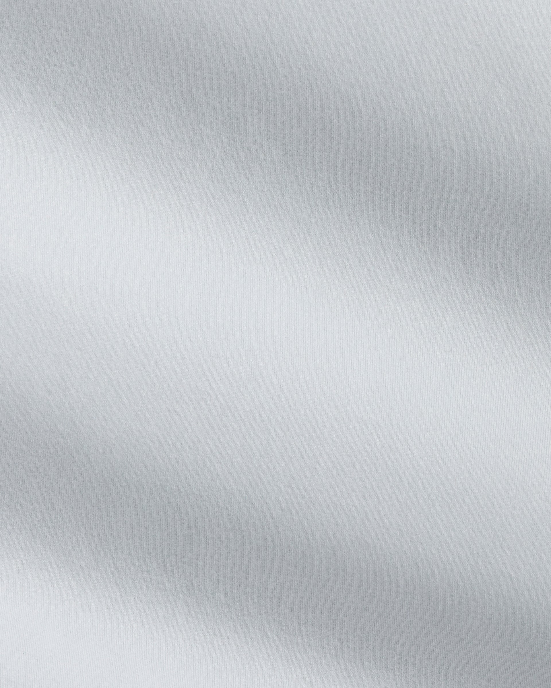 A close-up of a light gray fabric with a soft, textured surface and diagonal folds.