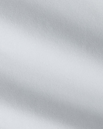 A close-up of a light gray fabric with a soft, textured surface and diagonal folds.