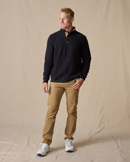 Men's Foothill V2 Placket in Black, full-length on-model lifestyle view featuring black fleece fabric, three-button placket with gold suede trim, styled with khaki pants and white golf shoes