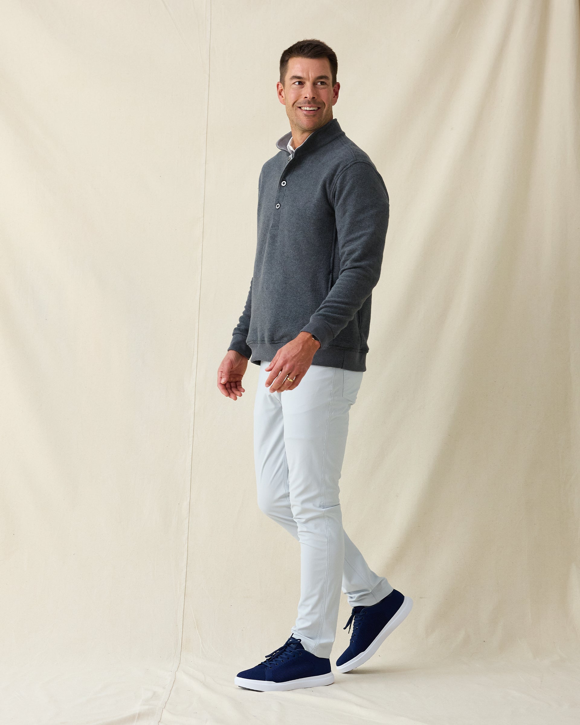 Men's Foothill V2 Placket in Charcoal, full-length side view on model featuring a charcoal heathered fleece pullover with snap button placket and mock collar, styled with light grey pants and navy shoes