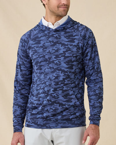 Front view of a man wearing the Mackenzie Hoodie in Moonlight over a white polo, showing the blue camouflage pattern and kangaroo pocket.