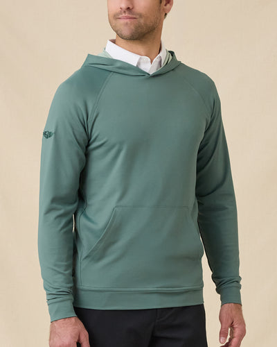 Model wearing the Mackenzie Hoodie in Dark Forest over a white polo, showing the pullover hood, raglan sleeves, and front kangaroo pocket.