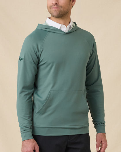 Model wearing the Mackenzie Hoodie in Dark Forest over a white polo, showing the pullover hood, raglan sleeves, and front kangaroo pocket.
