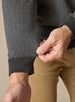 Men's Harrison Quarter Zip in Black, detail close-up view featuring a charcoal herringbone knit fabric with ribbed cuff detail, styled with khaki pants