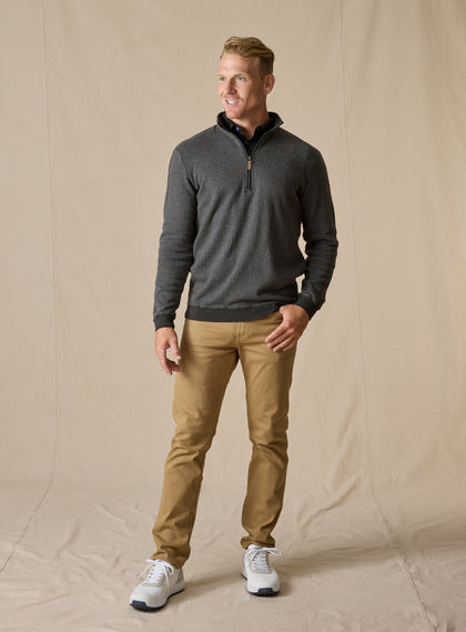 Men's Harrison Quarter Zip in Black, full length model view featuring a charcoal herringbone knit body with ribbed cuffs and hem and quarter-zip closure with leather pull tab, layered over a black collared shirt, styled with khaki pants and white shoes