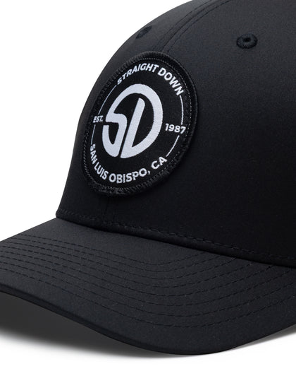 Circle Hat in Black White, close-up front detail view featuring a circular embroidered patch with the oversized SD monogram logo in white on a black ground, encircled by "Straight Down Est. 1987 San Luis Obispo, CA" text on the black front panel
