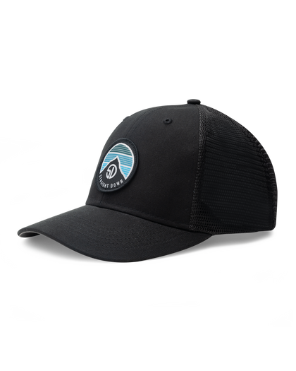 Night Landscape Hat in Black, angled side view featuring a black structured trucker cap with mesh back panels and a circular Straight Down logo patch with mountain and blue stripe design on the front panel