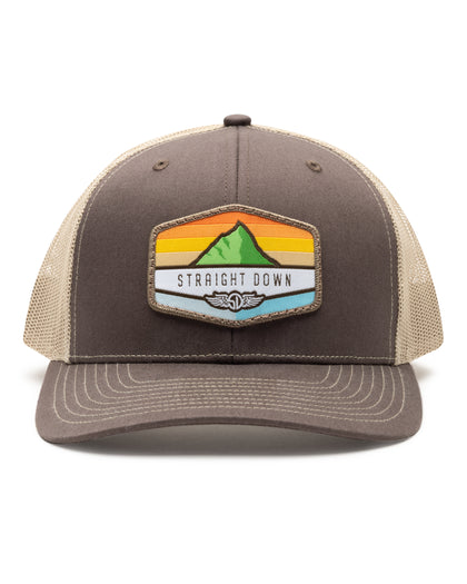 El Toro Hat in Brown, front view featuring a brown structured trucker cap with a woven mountain sunset landscape patch and Straight Down logo on the front panel, with tan mesh back panels and tan contrast stitching on the brim