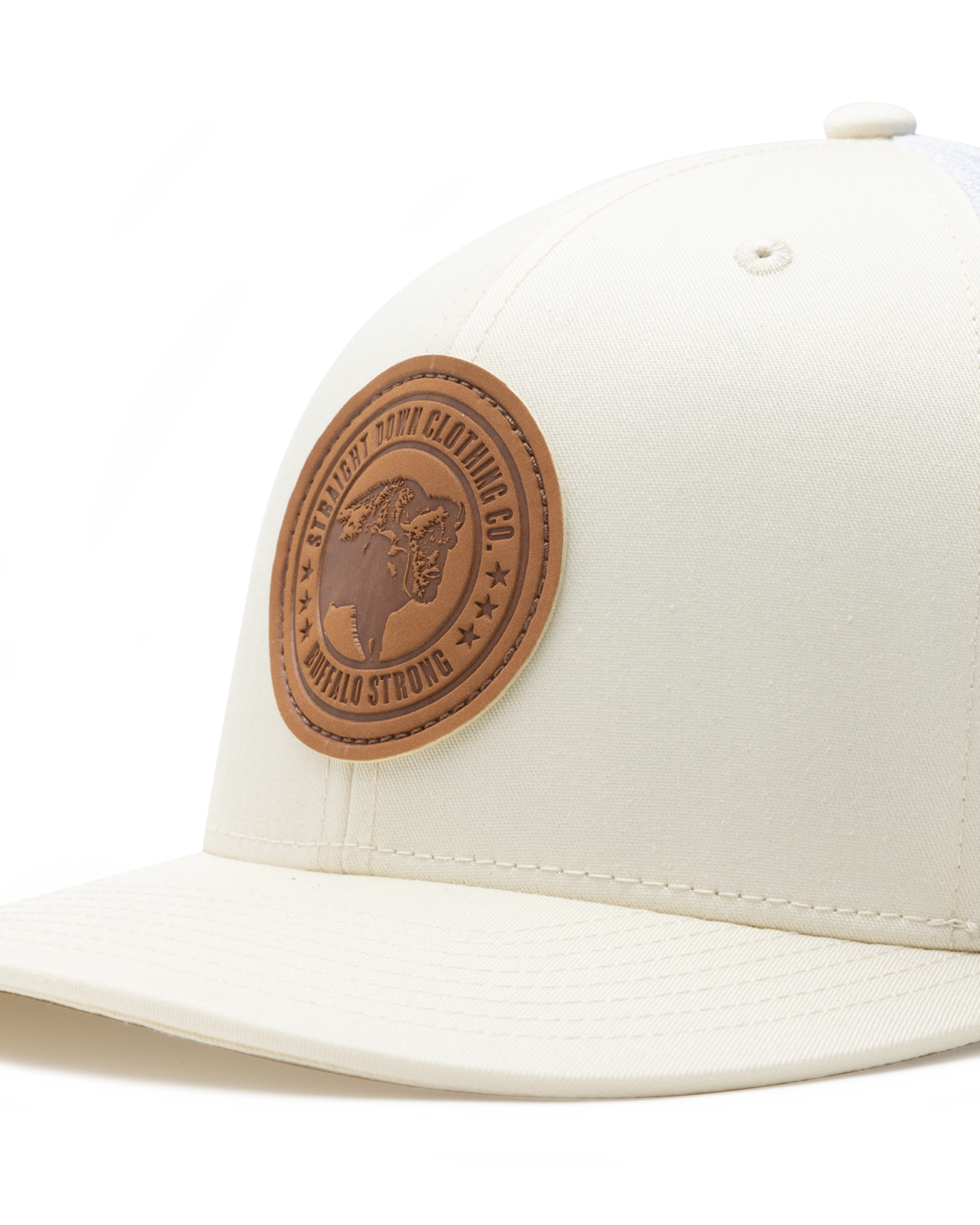 Straight Down SD Buffalo Strong Hat in Birch, close-up view showing brown leather Buffalo Strong circular patch detail on cream front panel