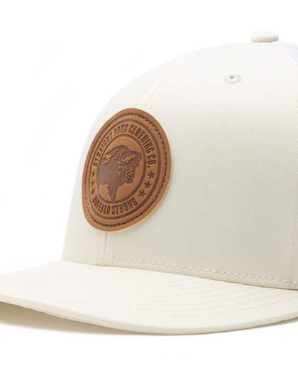 Straight Down SD Buffalo Strong Hat in Birch, close-up view showing brown leather Buffalo Strong circular patch detail on cream front panel