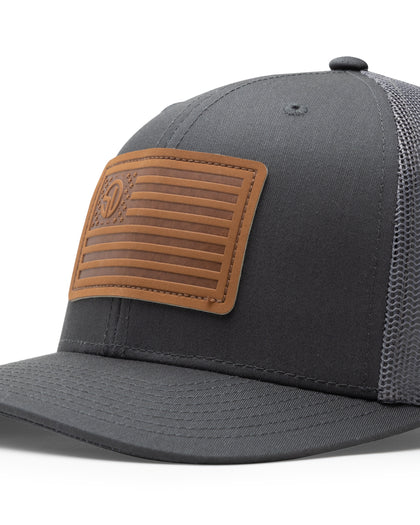 Straight Down SD Flag Hat in Charcoal, close-up view showing brown leather American flag patch detail with Straight Down logo on charcoal front panel