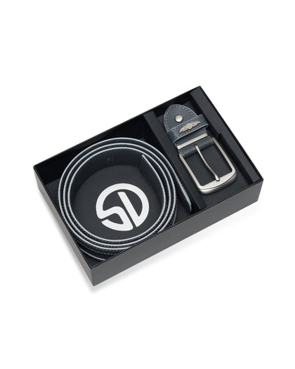 Men's Diplomat Belt in Phantom Smoke, flat lay gift box view featuring a black leather belt with contrast white stitching coiled in a branded black box alongside the detached gunmetal buckle with wing logo keeper detail
