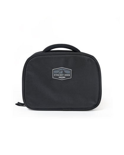Straight Down Montana Dopp Bag in Black, front view featuring a black toiletry bag with a Straight Down mountain badge logo patch, zip closure, and top carry handle