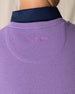 Men's Links Crewneck Sweater in Amethyst, close-up detail view of the tonal embroidered Straight Down winged logo at the upper back against the textured knit fabric, layered over a navy collared shirt