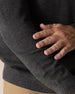 Men's Links Crewneck Sweater in Charcoal Heather, close-up detail view of the textured knit fabric and ribbed hem construction against the dark heathered gray fabric
