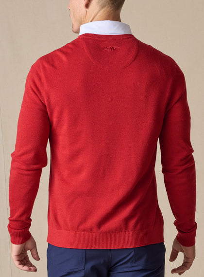Men's Links Crewneck Sweater in Flag Red, back on-model view featuring a bold red textured knit fabric with a tonal embroidered Straight Down logo at the upper back, styled with a white collared shirt and navy pants