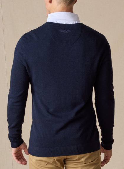 Men's Links Crewneck Sweater in New Indigo, back on-model view featuring a navy textured knit fabric with a tonal embroidered Straight Down logo at the upper back, styled with a white collared shirt and tan pants