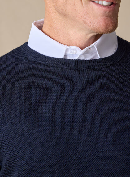 Men's Links Crewneck Sweater in New Indigo, close-up detail view of the ribbed crew neckline and textured knit fabric, layered over a white collared shirt