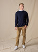 Men's Links Crewneck Sweater in New Indigo, full-length on-model view featuring a navy textured knit fabric with a crew neckline, styled with a white collared shirt, tan pants, and white shoes