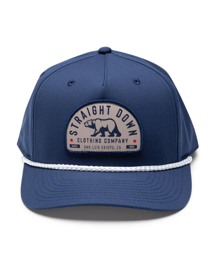 Bear Country Rope Hat in New Indigo, front view featuring a navy structured cap with a woven bear patch reading "Straight Down Clothing Company, San Luis Obispo, CA Since 1989" on the front panel, with a white rope brim detail