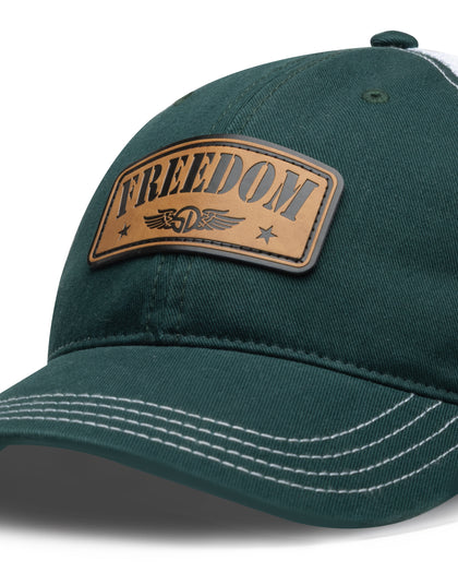 Freedom Hat in Green, close-up front detail view featuring a leather patch reading "Freedom" with the Straight Down logo and star accents on the forest green front panel with white contrast stitching on the brim